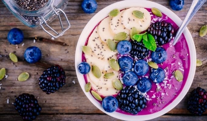 smoothie bowl topped with blueberries, blackberries, and dragonfruit