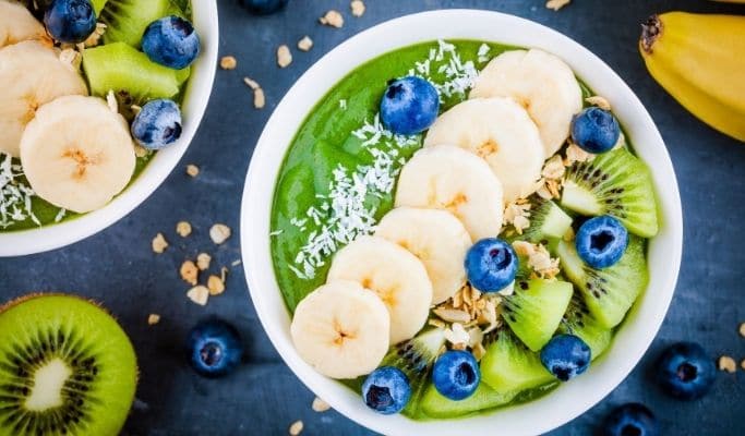why are smoothie bowls healthy - green smoothie bowl topped with kiwi, bananas, and blueberries