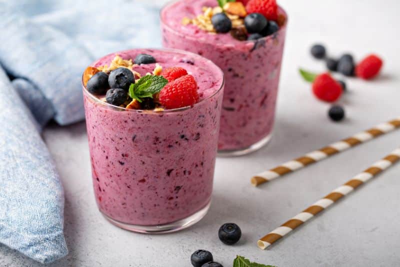 berry smoothies with almonds and granola on top