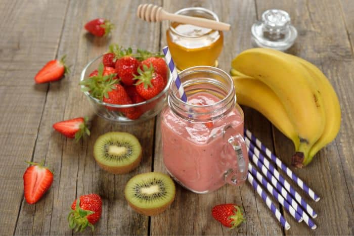 strawberry kiwi banana smoothie in mason jar glass