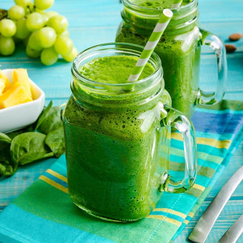 two green smoothies made with spinach and fruit