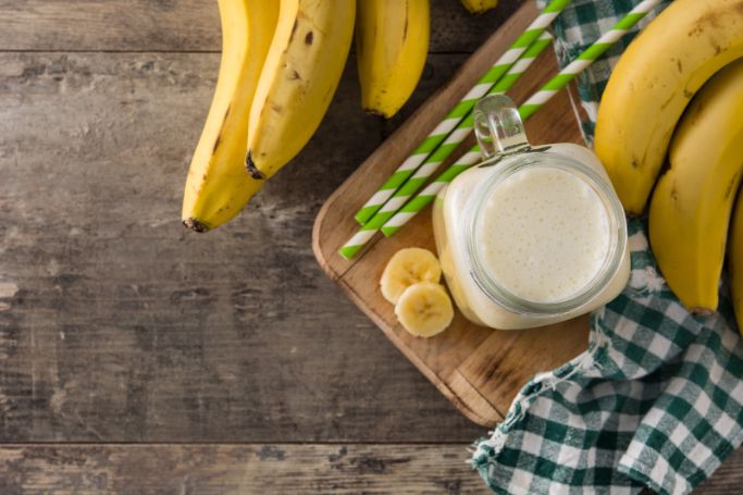 top view of banana smoothie surrounded by bananas