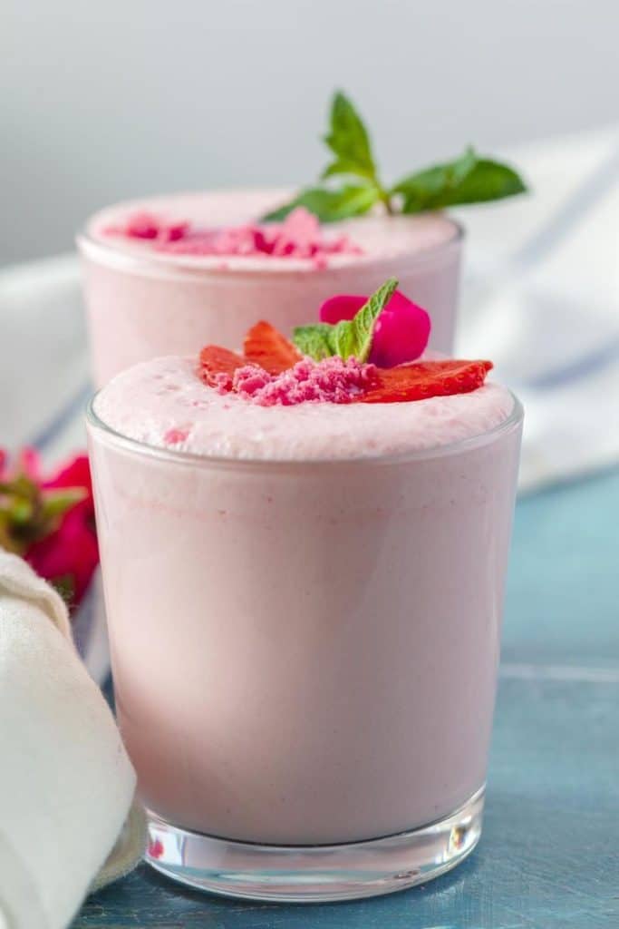 two pink fruit smoothies in glasses