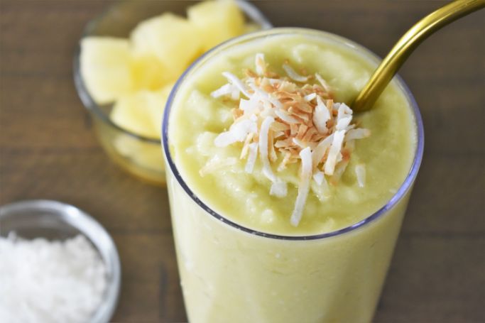 pineapple avocado smoothie topped with toasted coconut